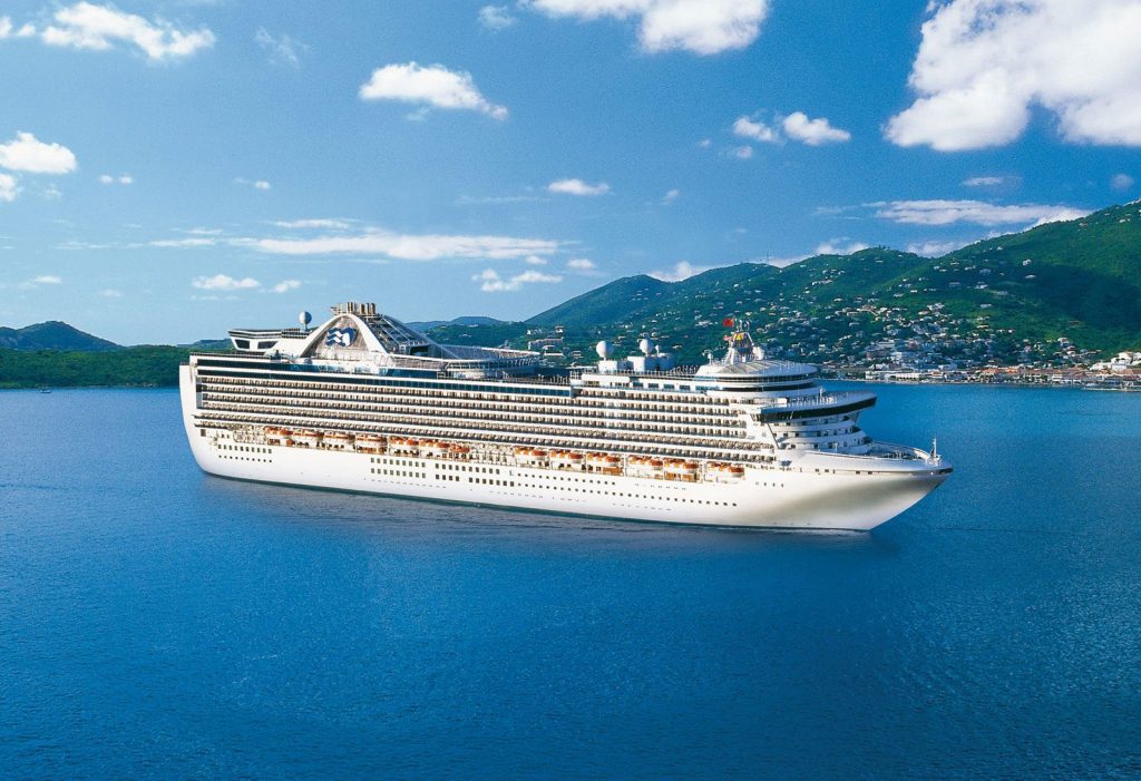 Person using laptop to book a cruise online with cruise ship images on screen