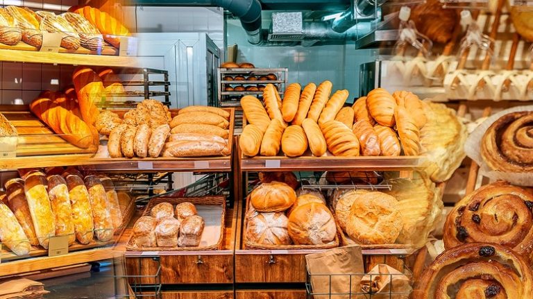 Assortment of gluten-free bakery items such as cakes, bread, and pastries on a display